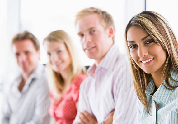 Four businesspeople sitting indoors smiling